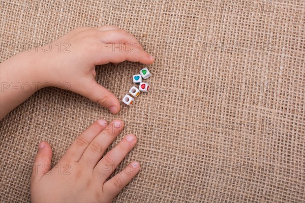 Little cubes with heart shape in hand on canvas