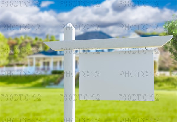 Blank real estate sign in front of new house