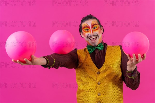 Clown with white facial makeup on a pink background