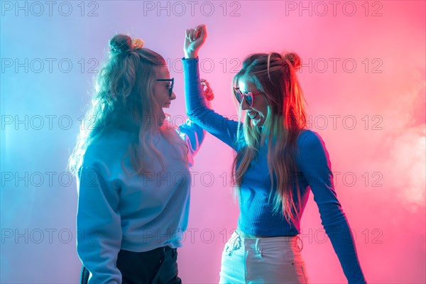 Two young blonde caucasian women dancing in nightclub