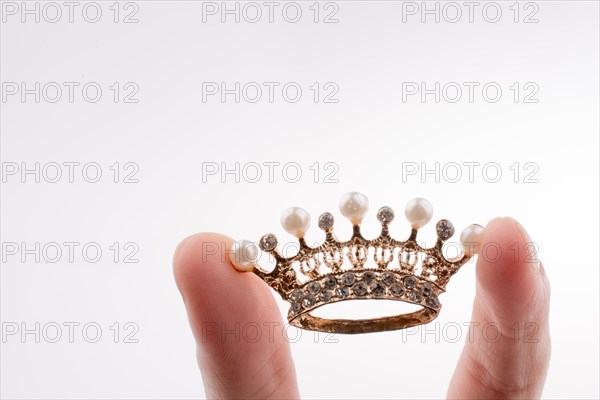 Golden color crown model with pearls on white background