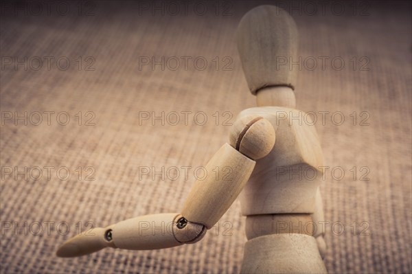 Wooden dolls of a man posing on canvas