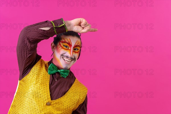 Clown with white facial makeup showing an empty space from the pink background