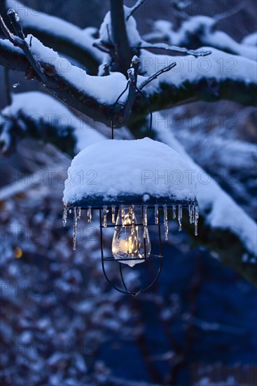 Solar garden light covered with snow at dusk