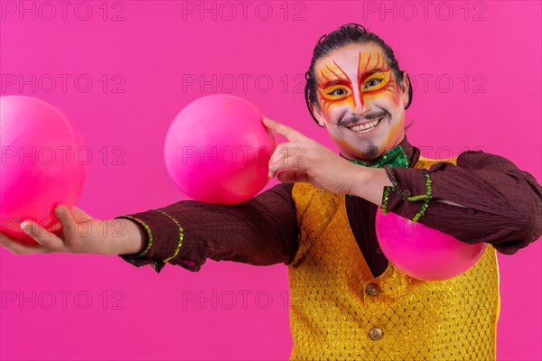 Clown with white facial makeup on a pink background