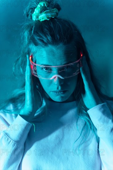 Woman with futuristic glasses gesturing against a blue background