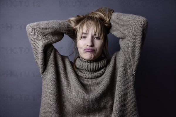 Young woman with long blond hair and a woollen jumper