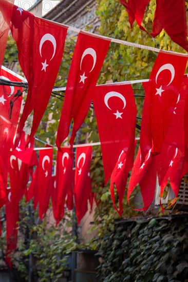 Turkish national flag hang on a pole on a rope in the street in open air