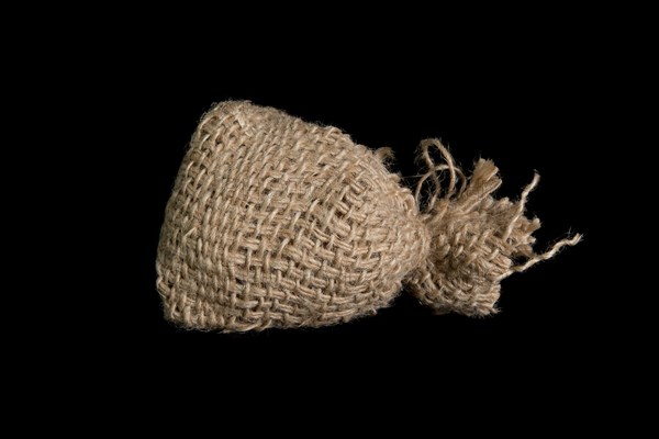 A small jute bag on a black background. In studio