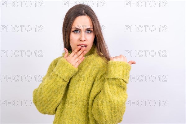 Attractive woman smiling pointing fingers at copy space on white background