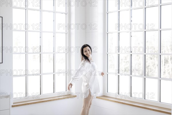 Attractive woman in a white shirt in front of a window