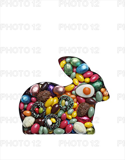 Easter bunny in baking tin filled with sweets on white