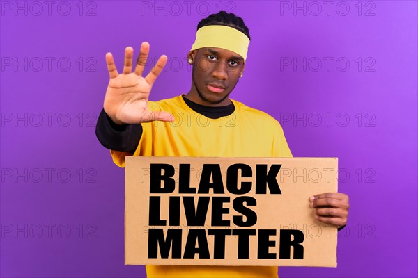 Black ethnic man in yellow clothes on a purple background