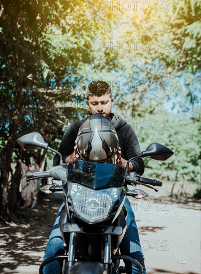 Motorcyclist putting on safety helmet