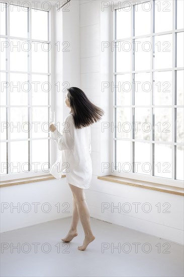 Attractive woman in a white shirt in front of a window