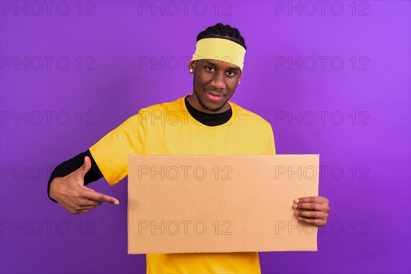 Black ethnic man in yellow clothes on a purple background