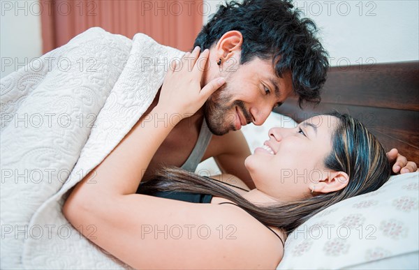 Couple waking up with a kiss in the morning