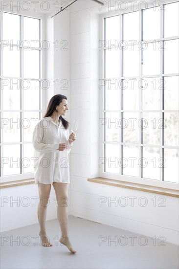 Attractive woman in a white shirt in front of a window