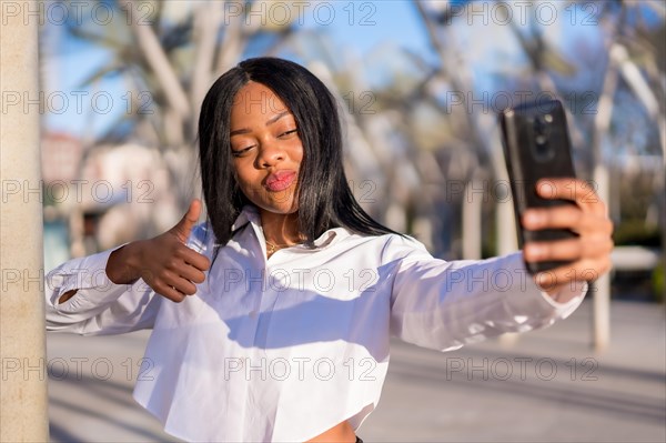 Young african woman in white clothes in the city at sunset