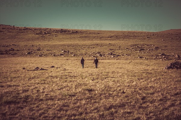 Hikers with backpacks and trekking poles walking in Turkish highland