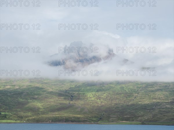 Fog drifts over mountainside