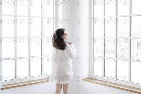 Attractive woman in a white shirt in front of a window