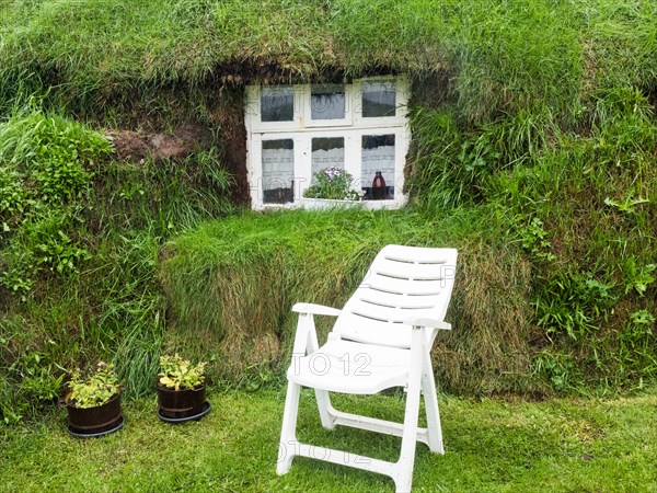 Folding chair in front of window