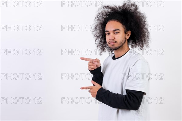 Pointing to the left at a copy paste space. Young man with afro hair on white background