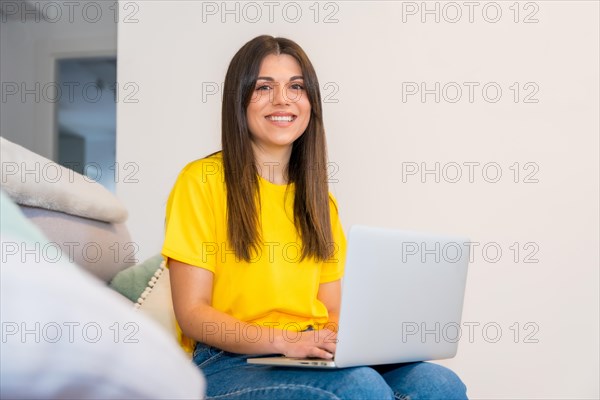 Portrait of woman with a computer sitting on a sofa