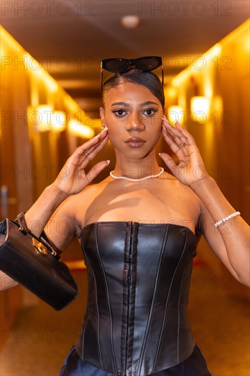 Fashion portrait of rich black ethnic woman posing in hotel room corridor