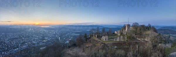 Panorama of the Hohentwiel castle ruins with the town of Singen am Hohentwiel in front of sunrise