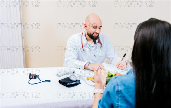 Nutritionist man giving consultation to woman patient in office