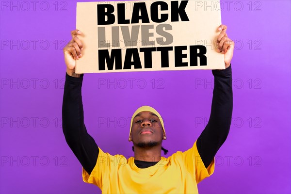 Black ethnic man in yellow clothes on a purple background