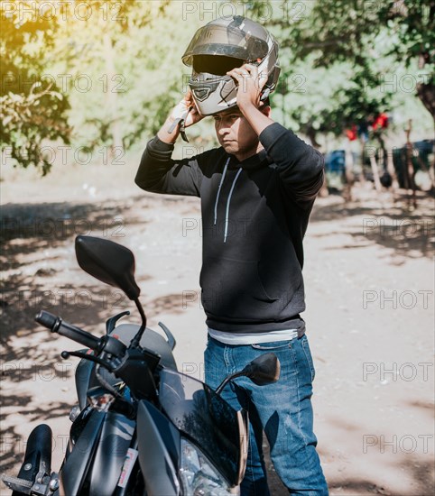 Close-up of motorcyclist man putting on safety helmet. Person on motorcycle putting on safety helmet