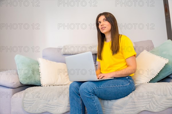 Woman with a computer sitting on a sofa