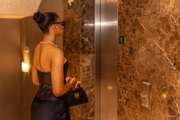 Rich black ethnic woman taking the hotel elevator