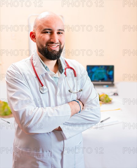 Smiling nutritionist doctor with crossed arms in her office. Portrait of smiling professional nutritionist