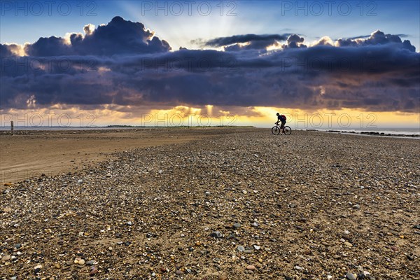 Cyclist on shingle beach