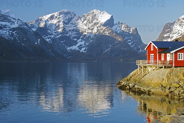 Rorbuer and high mountains reflected in a fjord