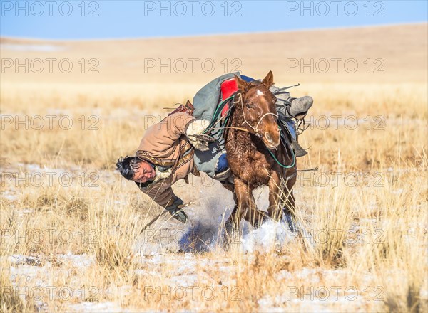 A rider picking up his pole from the ground. Dornod Province