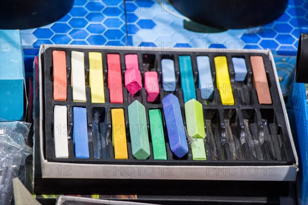 Crayons of various color in a box on a canvas