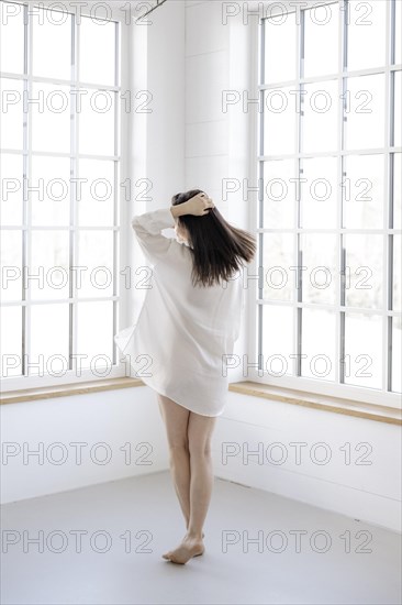 Attractive woman in a white shirt in front of a window