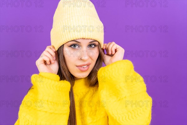 Close up portrait of young caucasian woman in yellow sweater isolated on yellow background