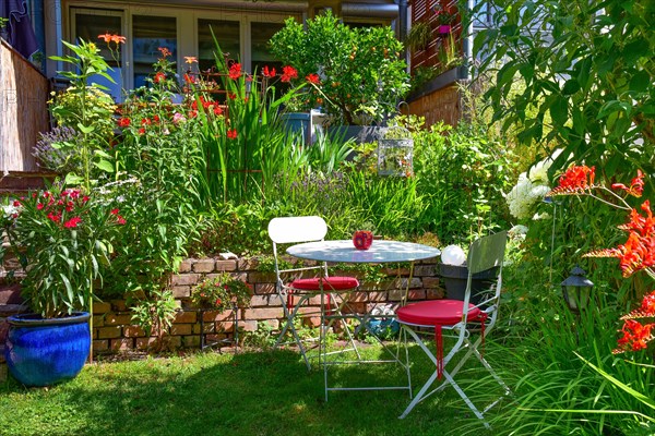 Garden chairs with table in front of a wall in a garden