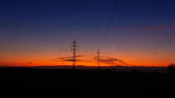 High voltage poles standing on the background of the blue hour. Czech republic