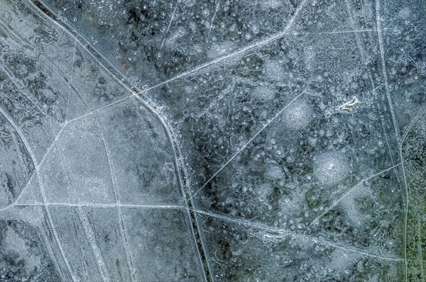 Air bubbles trapped in ice formed on a river during an icy winter. Alsace