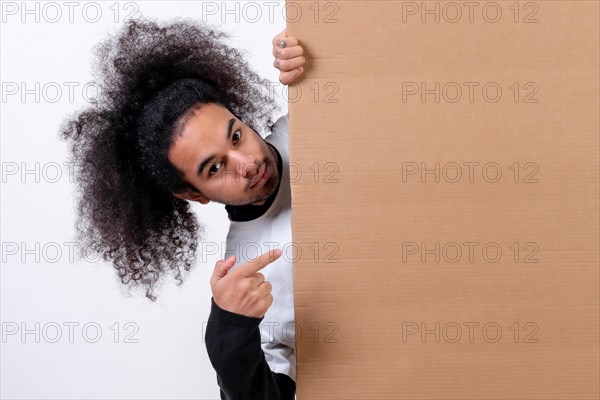 Smiling holding a sign with copy paste space. Young man with afro hair on white background