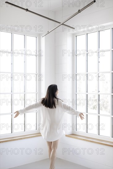 Attractive woman in a white shirt in front of a window