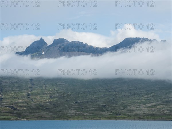 Fog drifts over mountainside