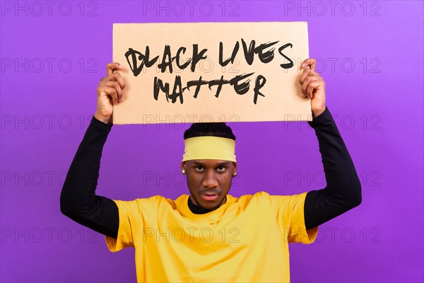 Black ethnic man in yellow clothes on a purple background